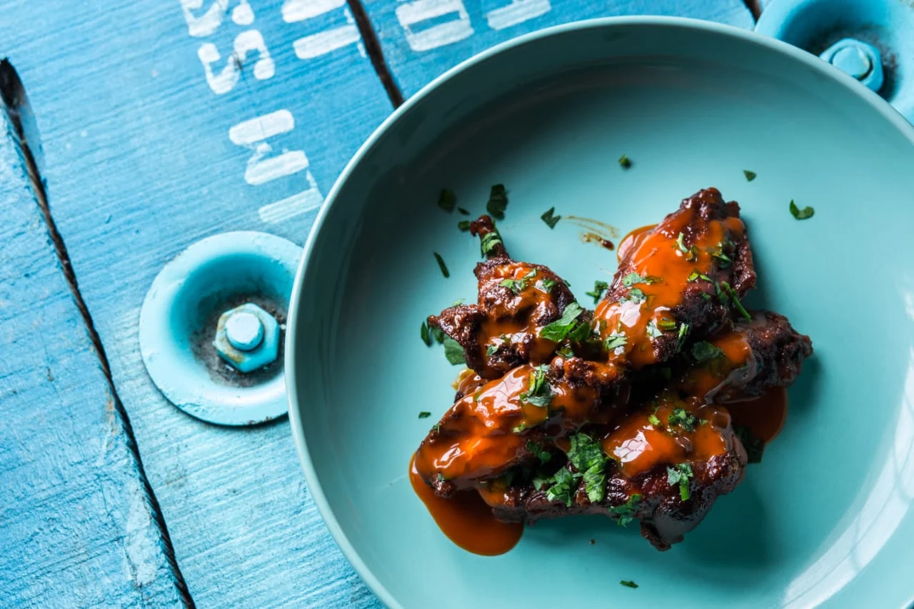 Fotografía de producto de alitas de pollo con salsa de Burger Planet